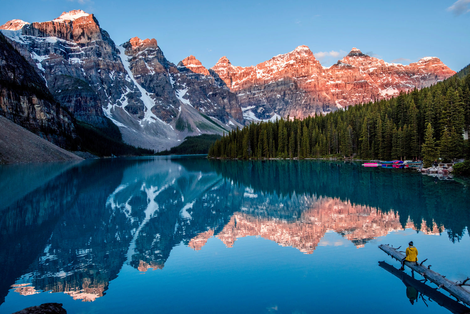 Clear blue lake at sunset with mountains and trees in the background